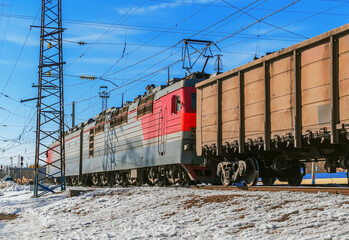 Electric locomotive is pulling a cargo train at one of the marshalling yard of Trans-Siberian Railway.