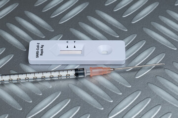 Antigen Schnelltest COVID-19 und eine Spritze zum Impfen / Impfung (2019-nCoV - coronavirus /...