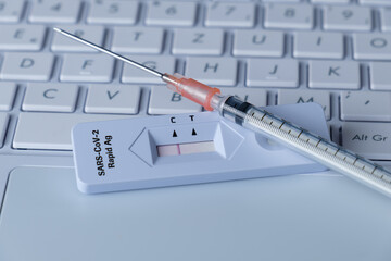 Spritze / Impfung und ein Antigen Schnelltest COVID-19 (2019-nCoV - coronavirus / SARS-CoV-2 virus...