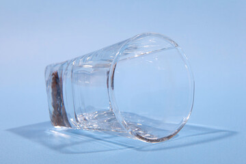 Empty inverted glass on blue background. Studio photo