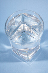 Glass with alcohol drink on blue background