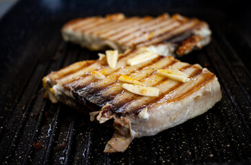 Pork steaks cooking on the grill. Selective focus. Pork animal in steak seasoned with garlic.