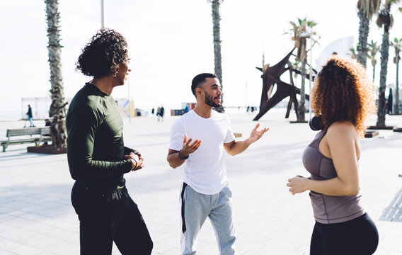 Cheerful diverse athletes talking and resting on street - Powered by Adobe