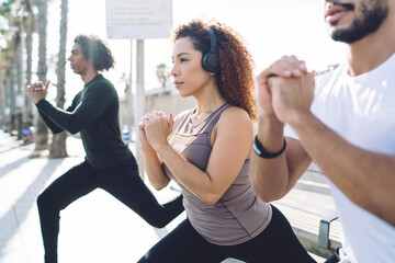 Diverse male and female colleagues warming up body muscles with effort for doing morning jogging...