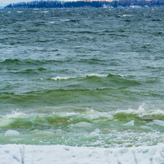 lake waves on snowy winter coast 
