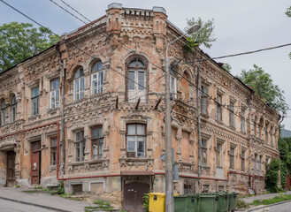 Abandoned building of the 19th century with the growing trees on the roof