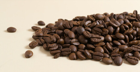 Coffee beans are scattered on a yellow background. Coffee concept. Selective focus. Copy space.