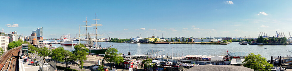 Fototapeta na wymiar Hamburg Landungsbrücken im Sommer am Hafen mit Blick auf die Elbe Richtung Hafencity - Panorama