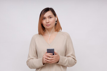Fototapeta premium Young beautiful girl in headphones on a white background.