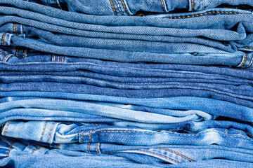 Neatly folded denim clothing. Background on the theme of jeans.