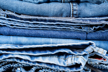 Neatly folded denim clothing. Background on the theme of jeans.