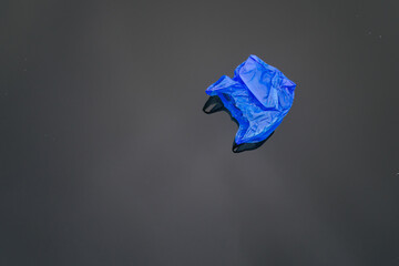 Blue plastic trash bag floating on water