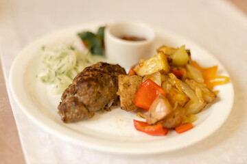 Lula Kebab with potatoes in a round white plate