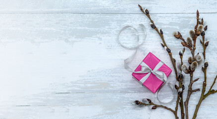 Pink box with yellow ribbon. Gift wrap and willow branches.