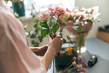 Gardener s in the flower shop make bouquet for a holiday. Lifestyle flower shop. Beautiful flower...