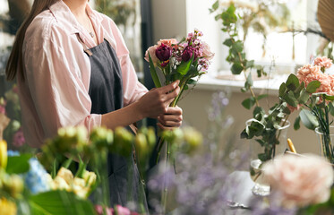 Gardener s in the flower shop make bouquet for a holiday. Lifestyle flower shop. Beautiful flower...