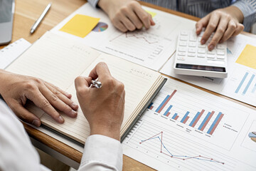 Two businessmen are working together to brainstorm how to grow the company and make plans to control the company's finances in accordance with the plan. Financial concept.