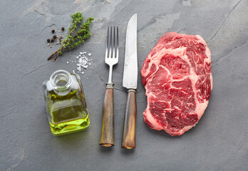 Ribeye beefsteak with spices on stone background