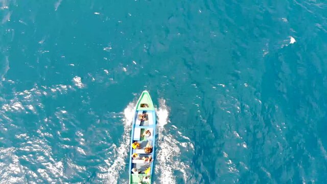 Water taxi carries people across turquoise ocean off Madagascar. Aerial drone view.