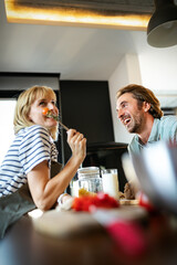 Happy couple cooking healthy food and having fun together in their kitchen