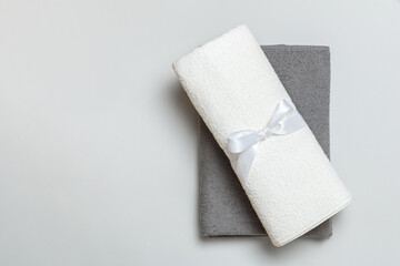 Top view of a stack of rolled up white and gray towels with copy space.