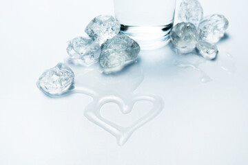 Transparent pieces of ice and water in the shape of a heart. focus on water.