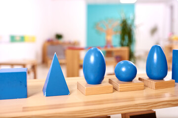 Light class in Montessori kindergarten. The blue Montessori geometric solids in the foreground. nobody