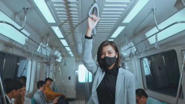 Asian business woman is wearing protective mask in metro train