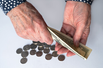 Close-up of an elderly woman's hand counting money on a white background. Retirement savings, home finance