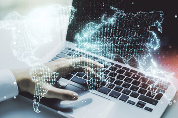 Abstract creative digital world map and hands typing on laptop on background, globalization concept. Multiexposure
