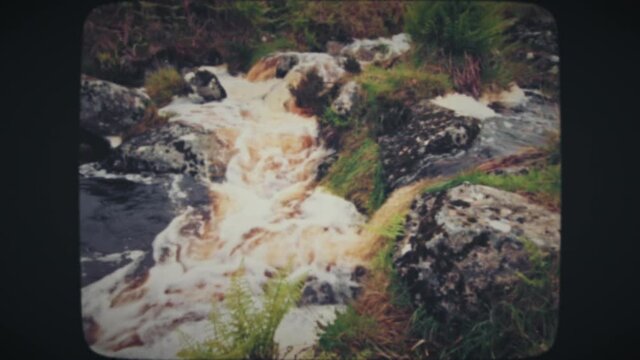 Beer-colored waterfall in the mountains of Ireland. Vintage Film Look. 