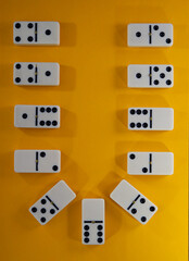 composition of dominoes lies on a yellow background.