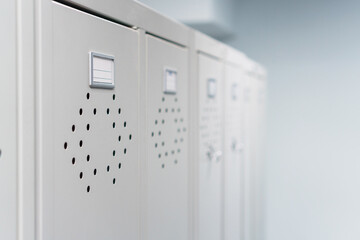 Gray metal lockers in the dressing room for clothes in a row.