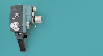 Fototapeta premium Vintage 8mm camera with 8mm reel on blue background.