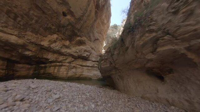 Extreme low angle shot of fpv drone flying between canyon rocky walls