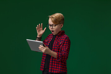 child boy in red checkered shirt using digital tablet