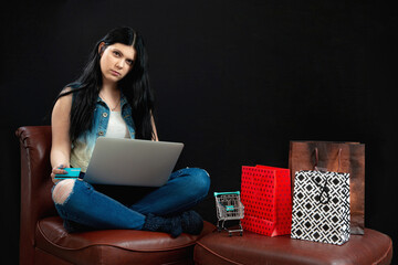 young woman with credit card using laptop for online shopping , isolated on black background
