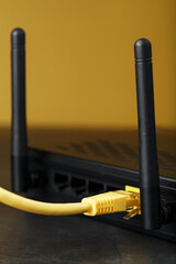 A yellow patch cord is inserted into the Wi-Fi port of the router to access the Internet.