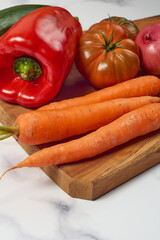 Various greens and vegetables on wooden kitchen table