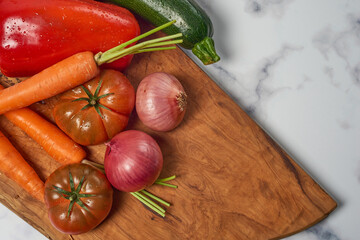 Various greens and vegetables on wooden kitchen table