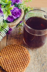Delicious waffles with tea on a wooden table. Vertical photography.