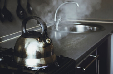 kettle boiling on a gas stove in the kitchen.