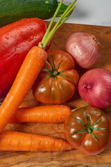 Various greens and vegetables on wooden kitchen table