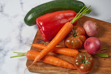 Various greens and vegetables on wooden kitchen table