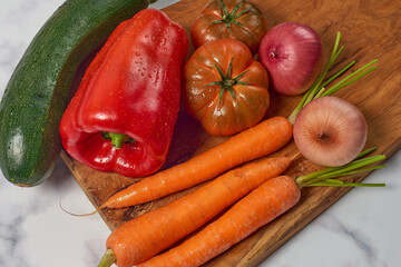 Various greens and vegetables on wooden kitchen table