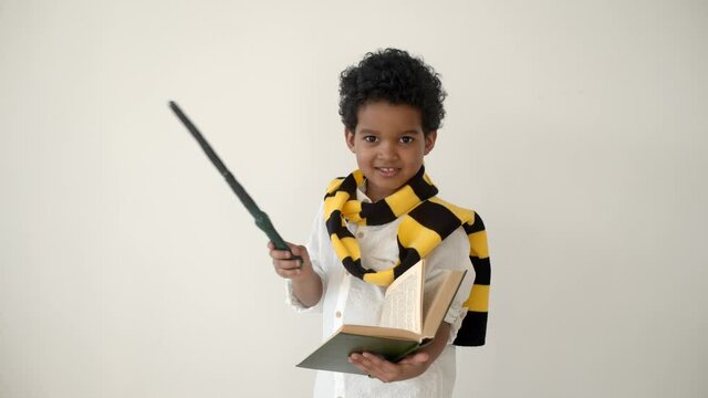 African american kid reading a book and holding magic wand