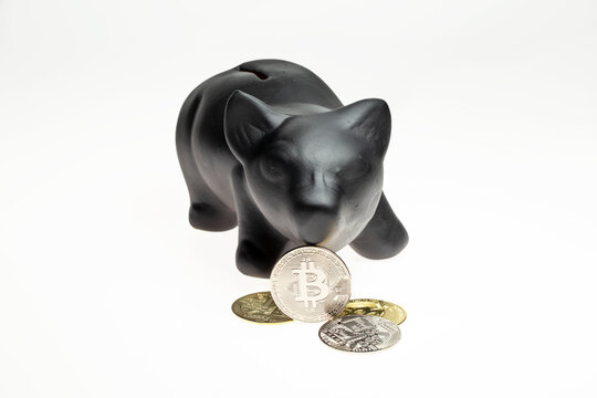 Cofrinho de porco preto de cer&acirc;mica com moedas de bitcoin em fundo branco, isolados para recorte.