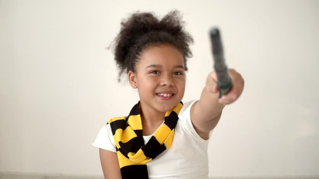 African american kid reading a book and holding magic wand
