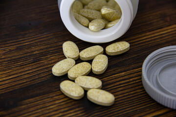 A jar of crumbled pills on a wooden table