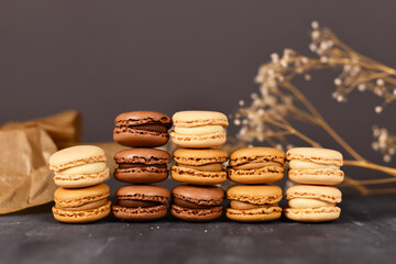 Stacks of natural brown, beige and cream colored French macarons with coffee, mocha, chocolate and vanilla flavour 